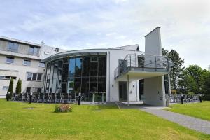 a building with a balcony and a grass field at Hotel und Kongresszentrum Wanderath in Baar