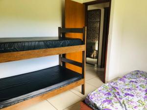 a room with two bunk beds and a doorway at Casa Mar e Montanha 1 in Trindade