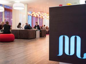 a sign for theofi company in a lobby with people at Motel L Hammarby Sjöstad in Stockholm