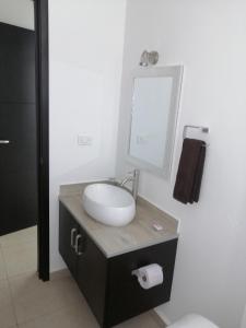 een badkamer met een wastafel en een spiegel bij Condo Kiaraluna in Playa del Carmen
