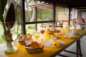 a table with baskets of bread and glasses of wine at Pousada Gata Russa in Saco do Ceu