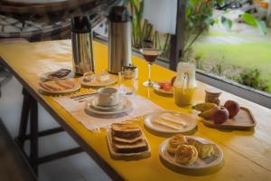 a table topped with plates of food and glasses of wine at Pousada Gata Russa in Saco do Ceu +63 photos