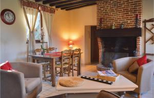 uma sala de estar com uma mesa e uma lareira em Gorgeous Home In Romery With Kitchen em Romery