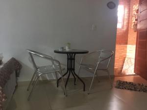 a table and two chairs in a room at SUITE - CIDADE das CACHOEIRAS in Santa Rita de Jacutinga