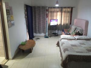 a bedroom with a bed and a table and a tv at SUITE - CIDADE das CACHOEIRAS in Santa Rita de Jacutinga