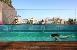 una mujer tendida en el agua en una piscina en Lux Lisboa Park, en Lisboa