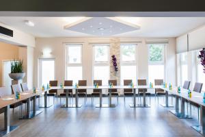 a conference room with a long table and chairs at SleepinRoomz Boutique Hotel in Dortmund