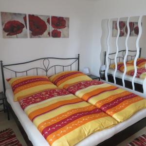 2 camas con mantas de colores encima en Ferienwohnung Brigitte Perner, en Nussdorf am Attersee