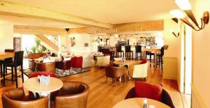 a restaurant with tables and chairs and a bar at The Farmhouse Hotel and Restaurant in St. Saviour Guernsey