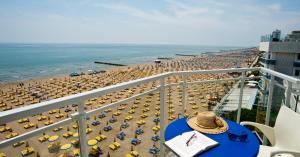 a balcony view of a beach with umbrellas and the ocean at Hotel Nizza Frontemare Superior 3 Stelle in Lido di Jesolo