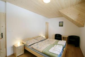 a bedroom with a bed and a wooden ceiling at Penzión Kohútik in Oravská Lesná +26 photos
