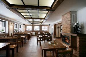a restaurant with tables and chairs and a fireplace at Penzión Kohútik in Oravská Lesná