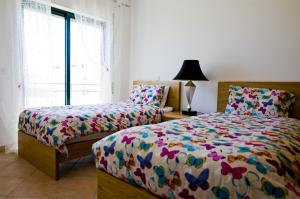 Un dormitorio con dos camas y una ventana. en Dalia, en Quarteira 16 fotos más