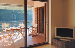 a room with a television and a balcony with a table at Apartment Labin 58 in Labin