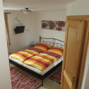 ein Schlafzimmer mit einem Bett mit bunten Decken in der Unterkunft Ferienwohnung Brigitte Perner in Nussdorf am Attersee