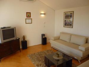 a living room with a couch and a tv at Apartment Panorama in Klis