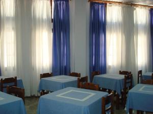 Habitación con mesas azules, sillas y cortinas en Pegasus, en Masouri