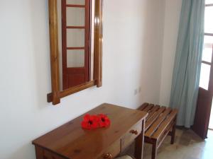 une table en bois avec une fleur rouge au-dessus dans l'établissement Pegasus, à Massouri