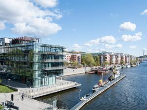 a large building next to a river with buildings at Motel L Hammarby Sjöstad in Stockholm
