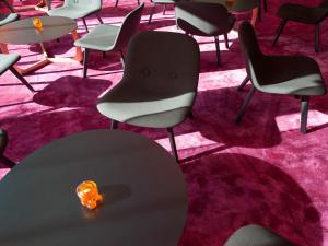 a table and chairs in a room with pink carpet at Motel L Hammarby Sjöstad in Stockholm