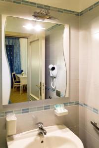La salle de bains est pourvue d'un lavabo et d'un grand miroir. dans l'établissement BB Santalucia, à Agerola