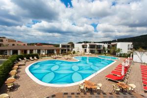 uma piscina com espreguiçadeiras e um resort em Assos Barbarossa Special Class Hotel em Behramkale