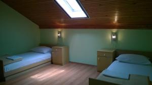 a room with two beds and a skylight at Rooms & Apartments Blue Beach in Vodice
