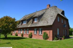 Cette grande maison en briques rouges est dotée d'un toit de chaume. dans l'établissement Luv - a05408, à Dunsum