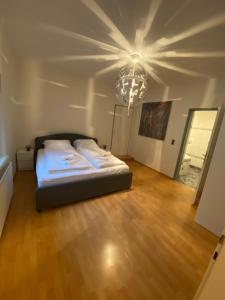1 dormitorio con cama y lámpara de araña en Urban Living Graz - Apartment Top 4 self check-in en Graz