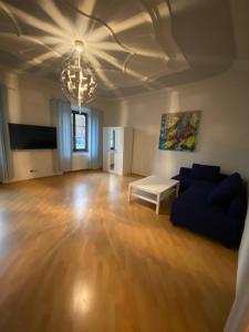 sala de estar con sofá azul y lámpara de araña en Urban Living Graz - Apartment Top 4 self check-in en Graz