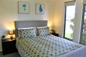 a bedroom with a bed and two lamps and a window at Clearwaters Albury in Albury