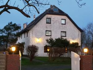 a large white house with lights in front of it at Bi Henning in Nordstrand