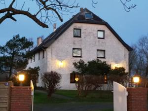 una gran casa blanca con luces delante en Ferienwohnung Jebeweg App. 9 en Nordstrand