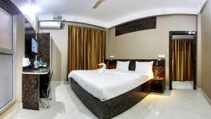 um quarto de hotel com uma cama e uma televisão em wings THE PRIDE em Jorhāt