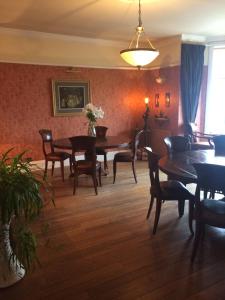 uma sala de jantar com mesas e cadeiras de madeira em Broom Lodge em Largs