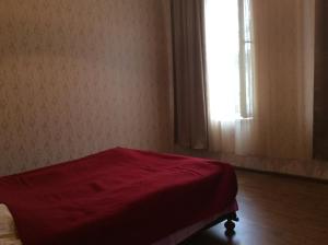 a red bed in a room with a window at Studio Lermontov Street in Tbilisi City