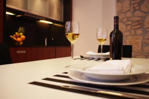 a table with two wine glasses and a bottle of wine at Guest House Villa Dagmar in Crikvenica