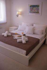 ein Bett mit zwei Getränken und ein Tablett mit Essen drauf in der Unterkunft Guest House Villa Dagmar in Crikvenica