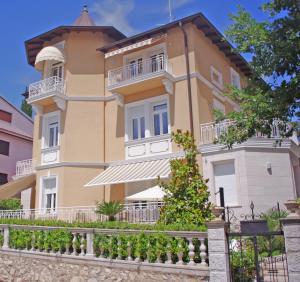 a large yellow building with a balcony at Guest House Villa Dagmar in Crikvenica
