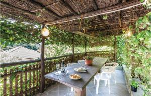 einen Holztisch und Stühle auf einem Balkon mit Reben in der Unterkunft Casa Del Minatore in Lorsica
