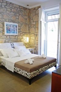 a bedroom with a bed and a stone wall at Guest House Villa Dagmar in Crikvenica