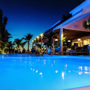 a large swimming pool in front of a hotel at night at TropiCoco Beach Resort Koh Phangan in Haad Yao
