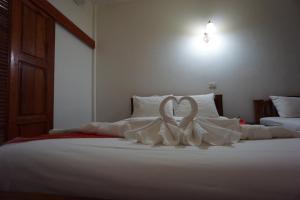 a bed with a white heart made out of pillows at Romsak Lanna Resort Chiang Mai in Chiang Mai