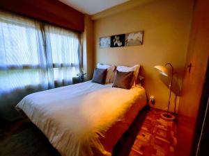 a bedroom with a large white bed with a window at Apartamento Puerto de Navacerrada in Cercedilla