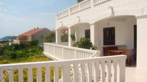 a white balcony of a house with a white fence at Apartments Topo in Hvar