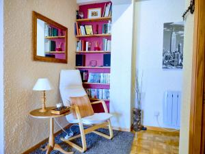 Habitación con mesa, silla y estante para libros. en Apartamento Puerto de Navacerrada, en Cercedilla