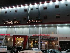 a building with cars parked in front of it at Al Shaiki Hotel in Al Jubail