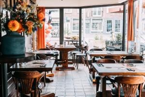 a restaurant with tables and chairs and a window at Hotel Café Restaurant Abina in Amstelveen
