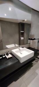 a bathroom with a white sink and a mirror at ZIBE Hyderabad by GRT Hotels in Hyderabad