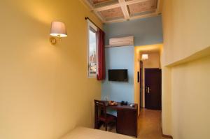 a room with a desk and a window and a bed at Hotel Cardinal of Florence , an Golden View Collection in Florence